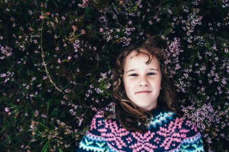 woman laying on green grassfield photo