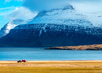 snow capped mountain next to body of water