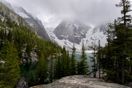 gray rock mountain leading to river and coated snow mountain photo