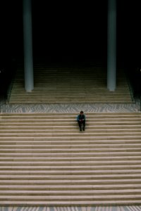 man sitting on a flight of stairs photo