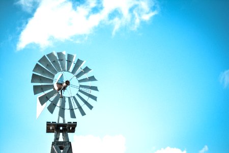 windmill under blue and white cloudy skies at daytime photo