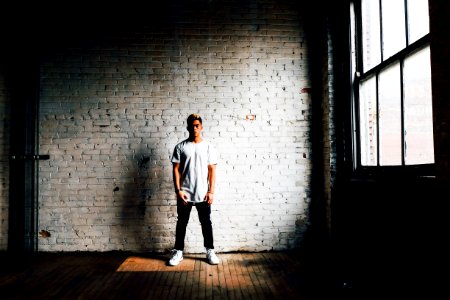 man standing in front of white wall