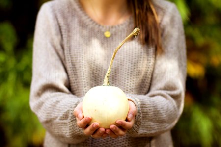 woman holding white round fruit outdoor photo