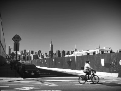 grayscale photo of person riding bicycle on road