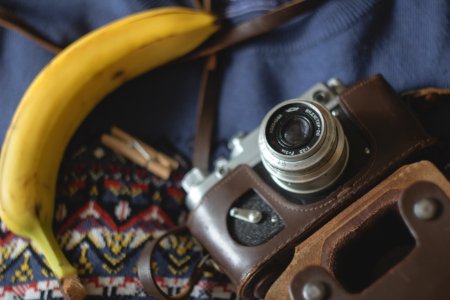 selective focus photography of camera beside banana photo