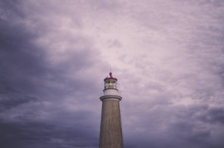brown lighthouse under cloudy daytime photo