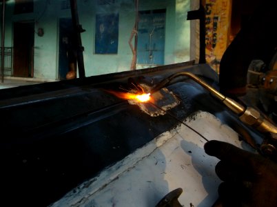 person welding black metal part photo