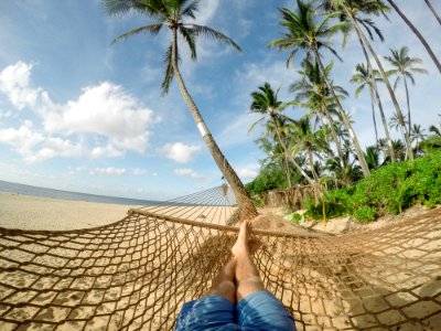 A person lying down in a hammock on the beach. photo