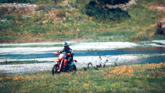 man riding motorcycle on body of water photo