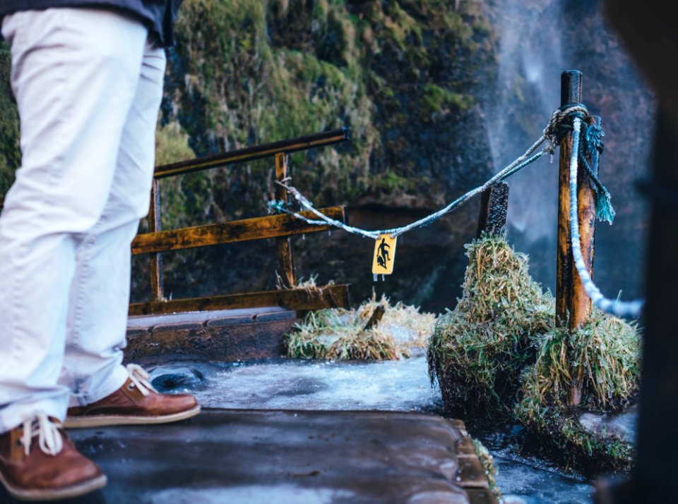 man standing near waterfalls during daytime