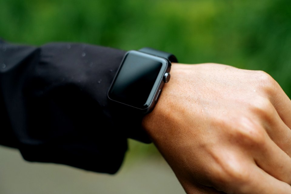 person wearing space gray Apple Watch turned off