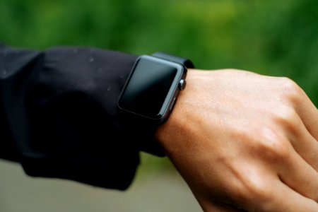 person wearing space gray Apple Watch turned off