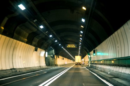 gray and white tunnel with lights turned on during night time