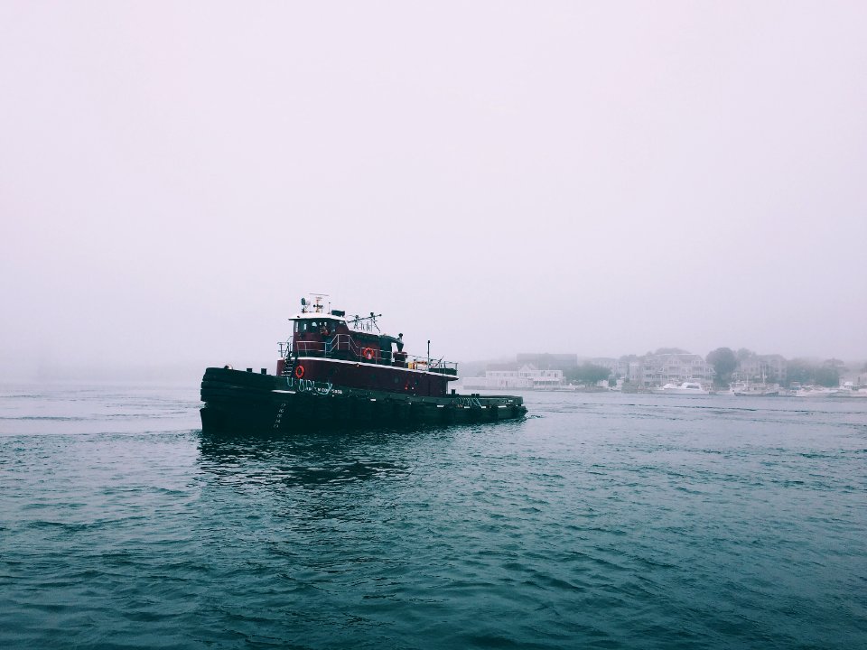 red and black boat on sea water