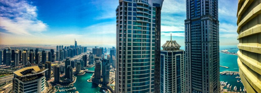 high rise buildings near body of water under blue sky