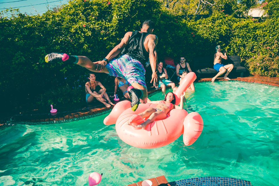 A man diving into a pool at a party.