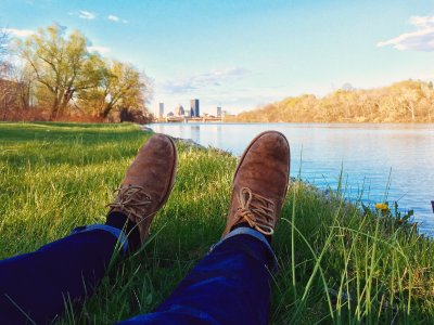 person lying on grass front of body ofwater photo