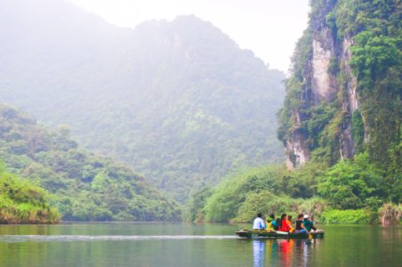 people in boat in water near mountains during daytime photo