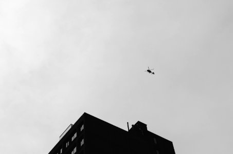 black helicopter flying under cloudy sky during daytime photo