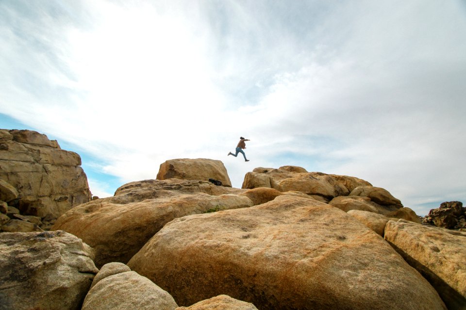 person jumping on rocks