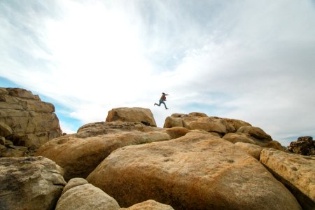 person jumping on rocks