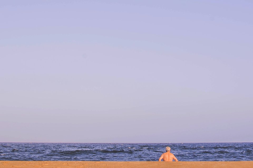 man sitting on seashore