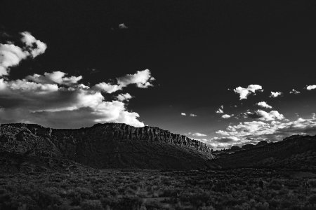 grayscale photo of mountain under cloudy sky photo