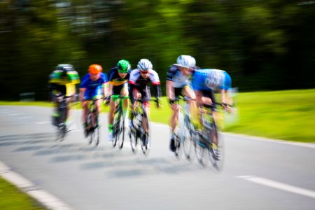 selective focus photography of cyclists on road during daytime photo