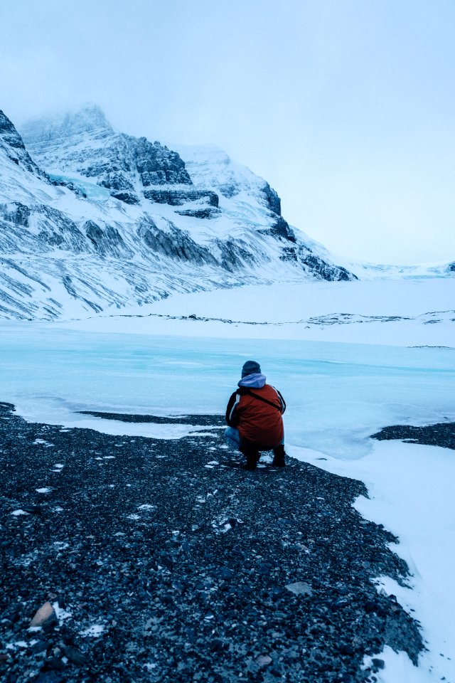 person siting facing mountain