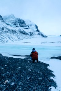 person siting facing mountain