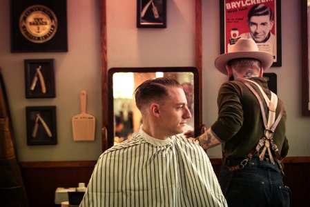 man sitting on chair inside barber shop photo