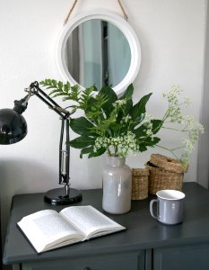 silver and black desk lamp beside white ceramic mug on black wooden table photo