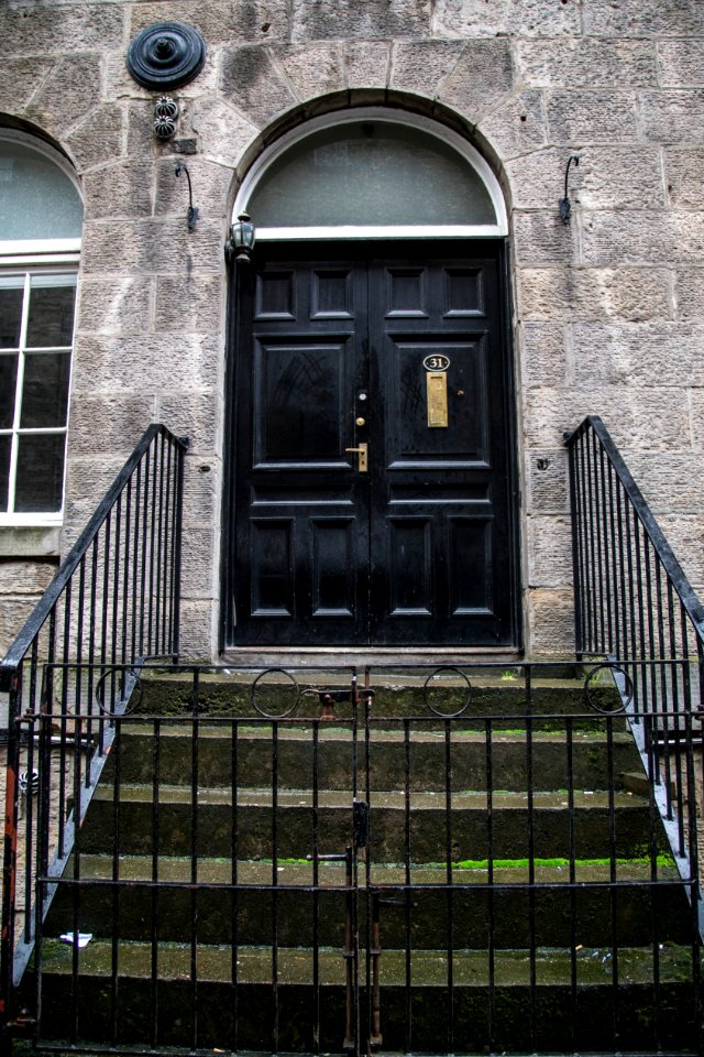 black wooden door on gray brick building