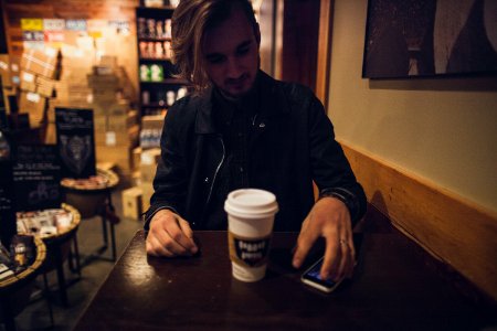 man sitting on chair holding phone photo