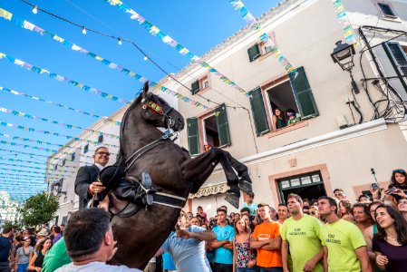 man riding house between people and building photo