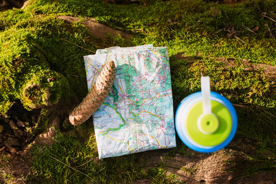 world map beside blue and green tumbler