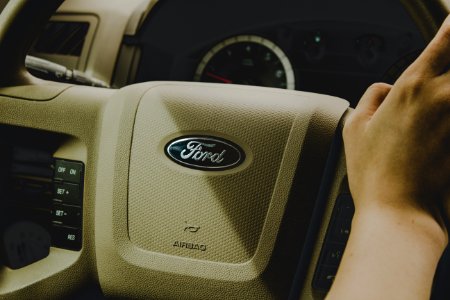 person holding Ford steering wheel photo
