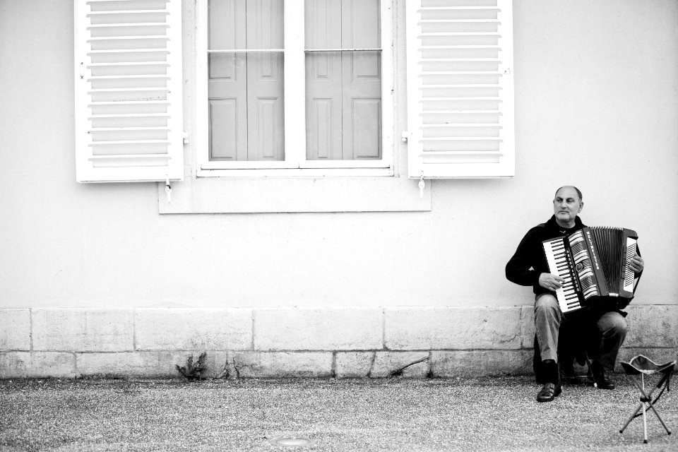 Accordionist under a window in black and white 