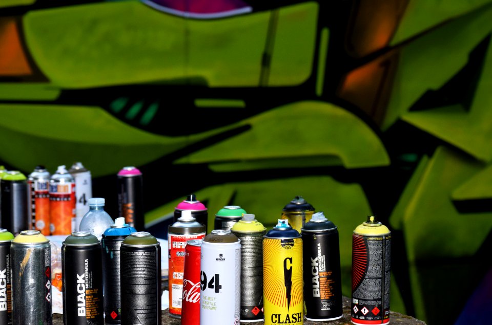 Spray cans in front of graffiti 