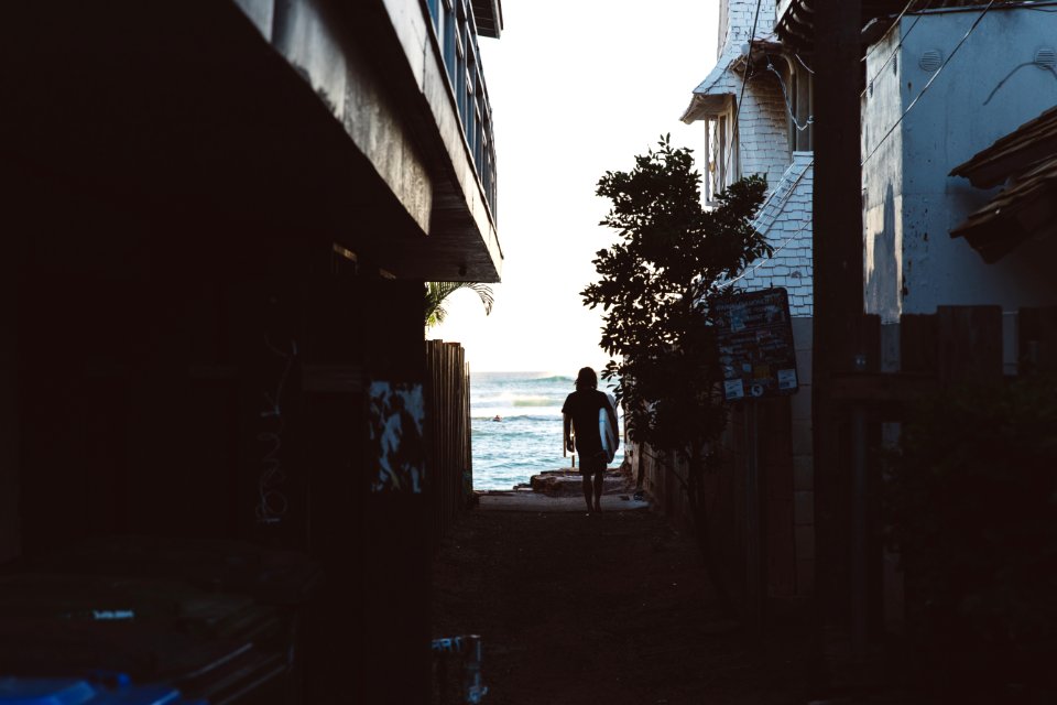 Surfer walking in the alley 