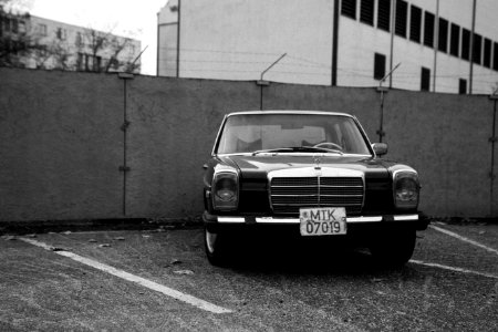 Black Vehicle Parked Near Concrete Wall in Grayscale Photography