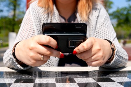 Person Holding Slide Qwerty Phone While Leaning on Table photo