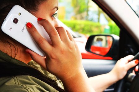 Woman Driving Car While Calling on Smartphone photo