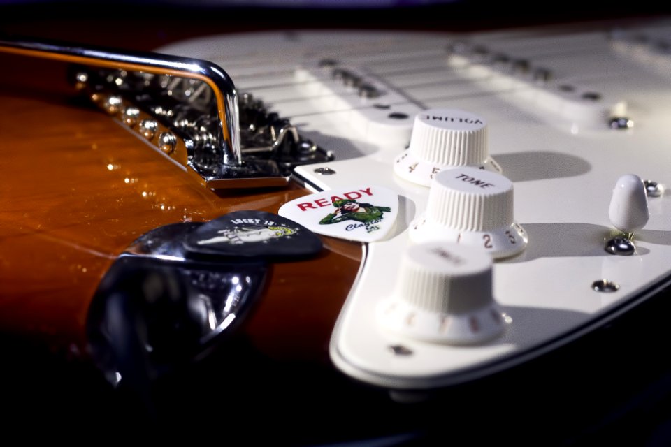Selective Focus Photo of Brown and White Electric Guitar