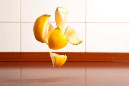 Sliced Lemon in the Air Beside the White Tiles photo