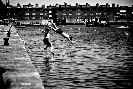 Boy and Girl Jumping in Body of Water photo