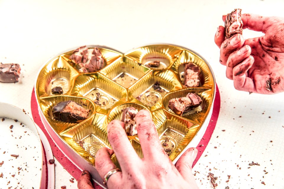 Person Picking Chocolate on Case photo