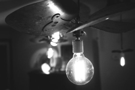 Grayscale Photography of Turned on Light With Ceiling Fan photo