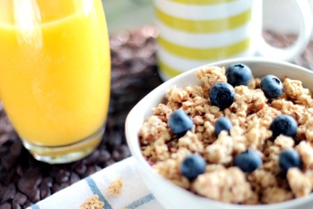Bowl of Oatmeal With Berries Beside Glass of Juice photo