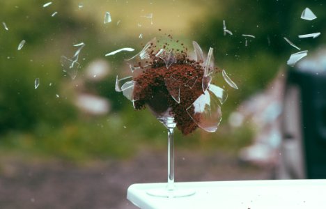 Selective Focus Photography of Broken Wine Glass With Brown Powder photo